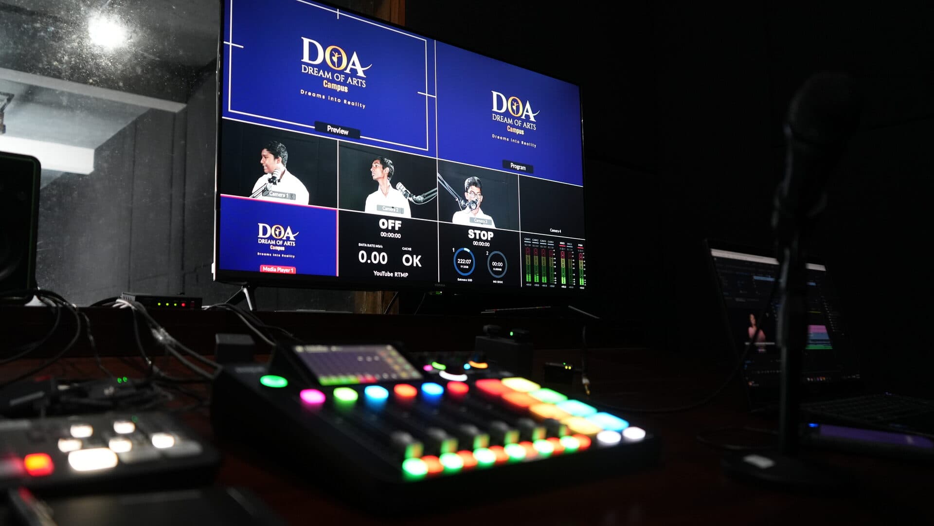 Wide shot of the broadcast control room with switcher panel and editing workstation