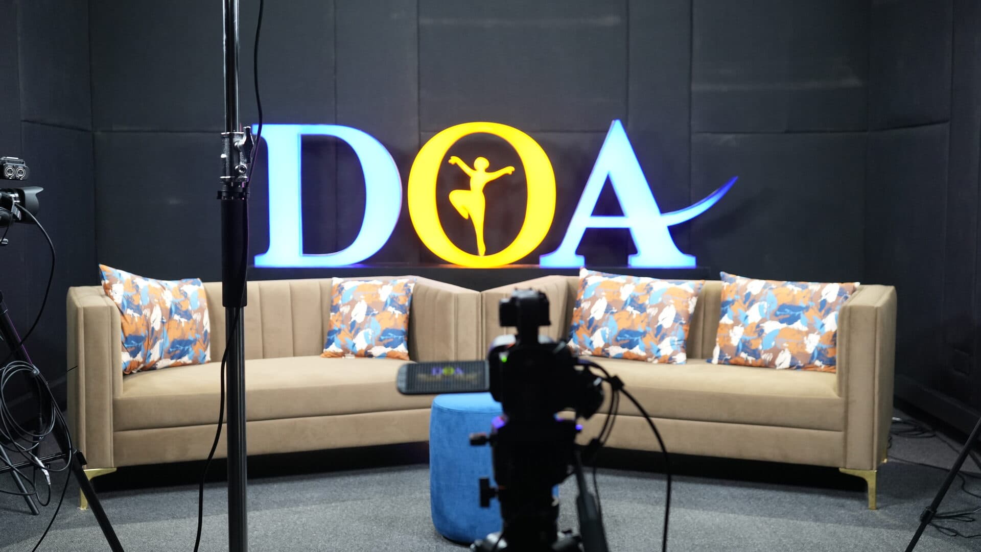 DOA School of Media TV studio set with branded backdrop and professional sofa