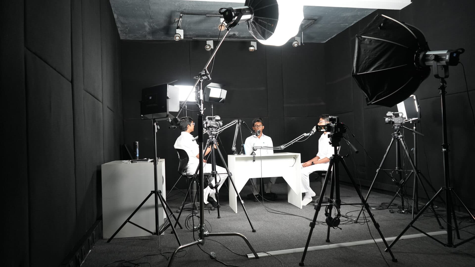 Full podcast studio setup with students and professional lighting rigs